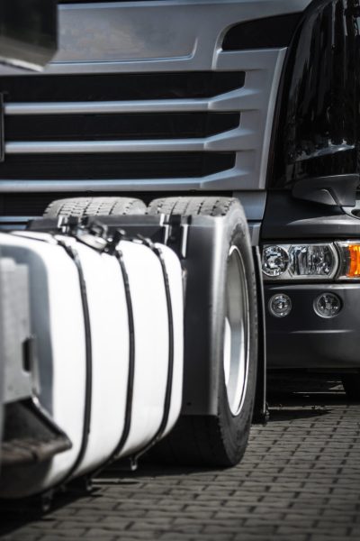 Euro Semi Trucks Staying in Traffic to the Storage Gate. Heavy Duty Transportation Theme.